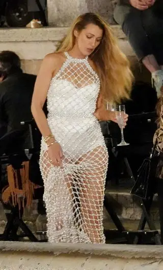 Blake Lively wearing a pearl beaded naked dress while walking down stairs