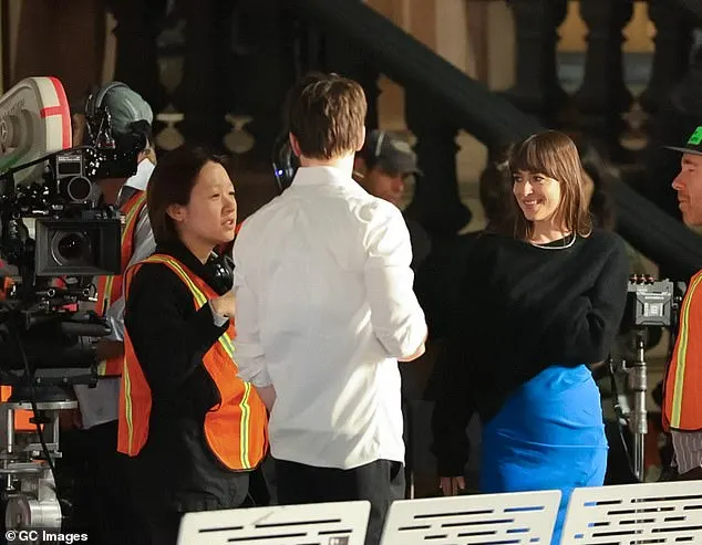 A chilly Dakota put on a black jumper to receive some pointers from director Celine Song