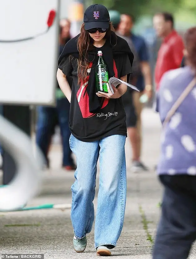 She wore a Rolling Stones T-shirt and wide-legged blue jeans with mint green trainers as she headed back to her scene