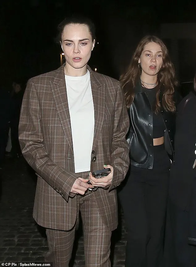 Carawore a brown checked suit co-ord with a casual plain white t-shirt and a pair of trainers. Minkesported a pair of smart black trousers and a black crop top under a leather jacket