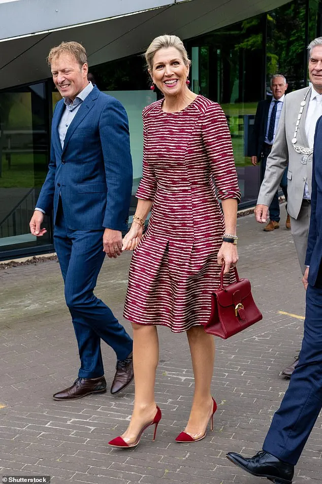 The Dutch queen smiled for photographers as she entered the conference