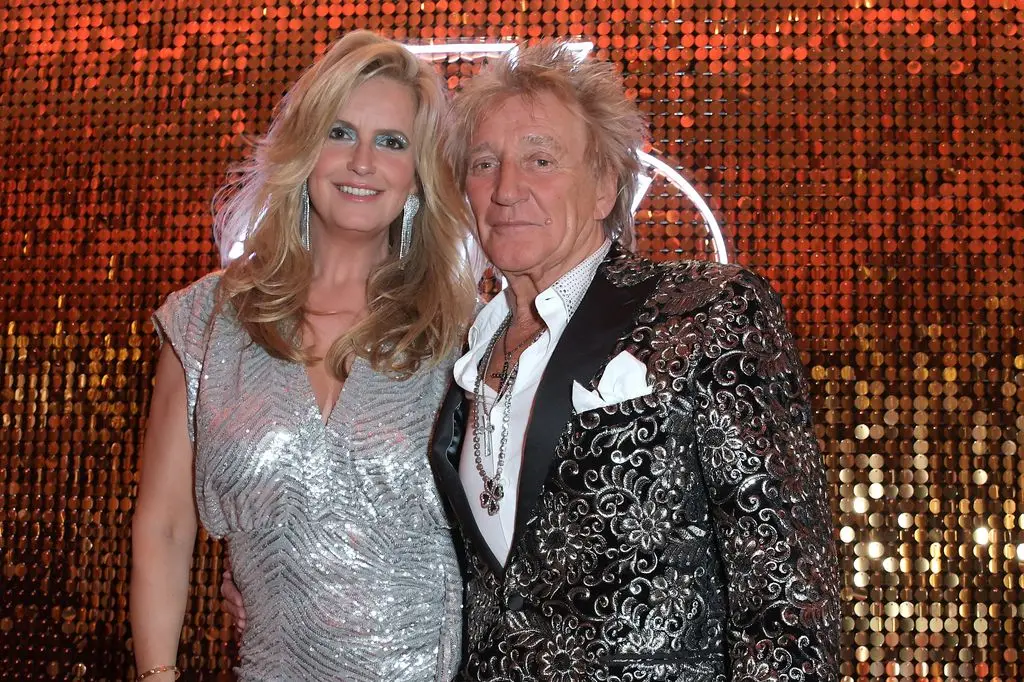 Penny Lancaster and Sir Rod Stewart against shiny backdrop