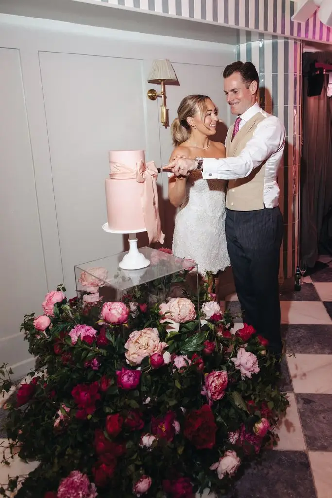 Alice Liveing and her husband cutting their wedding cake