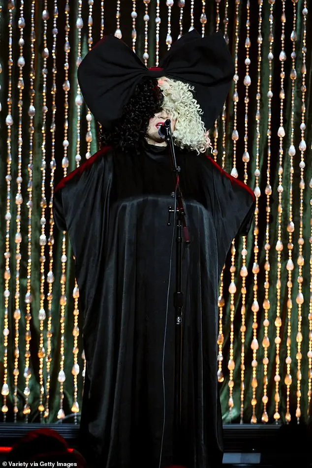 She belted out her chart-toppers while wearing a silky black robe with red detailing on the shoulders and sleeves