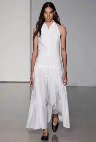 halter dress trend on Tove's spring 2024 runway with a model wearing a white maxi styled with black pointed flats