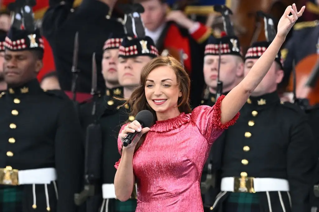 helen george singing on stage in pink dress