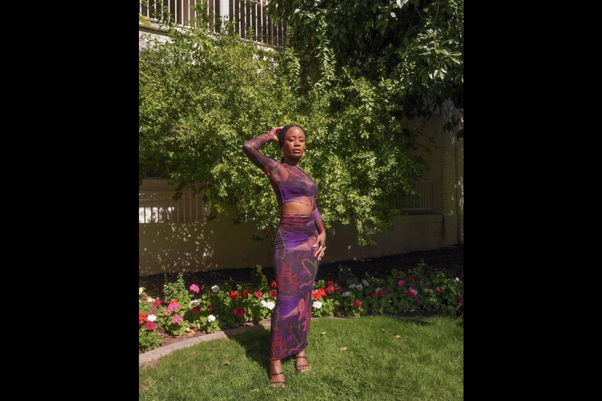 Woman models colorful dress outside.