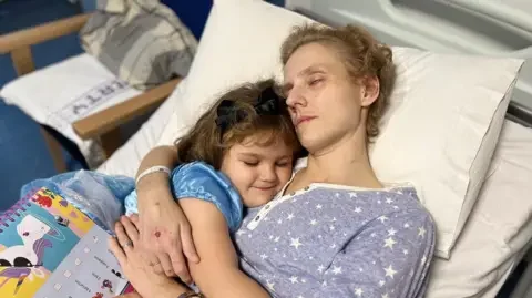 Family image Poppy in her princess dress cuddling her mother in hospital