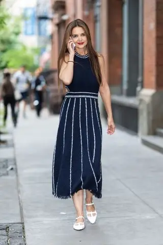 Katie Holmes wears a navy dress with blue stripes along with white shoes in soho