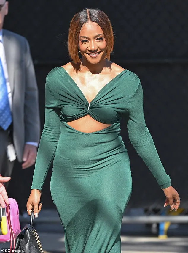 The comedian-turned-singer, 44, flashed her toned tummy in a fitted dark green cutout dress