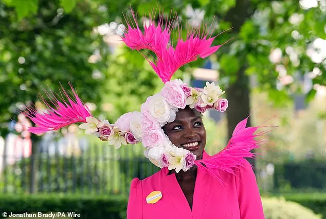 A racegoer put on a bright display in a fuchsia hat with an avant-garde flower-themed fascinator