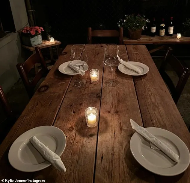 Jenner included a picture of a wooden table that was set for dinner with white plates as well as two candles