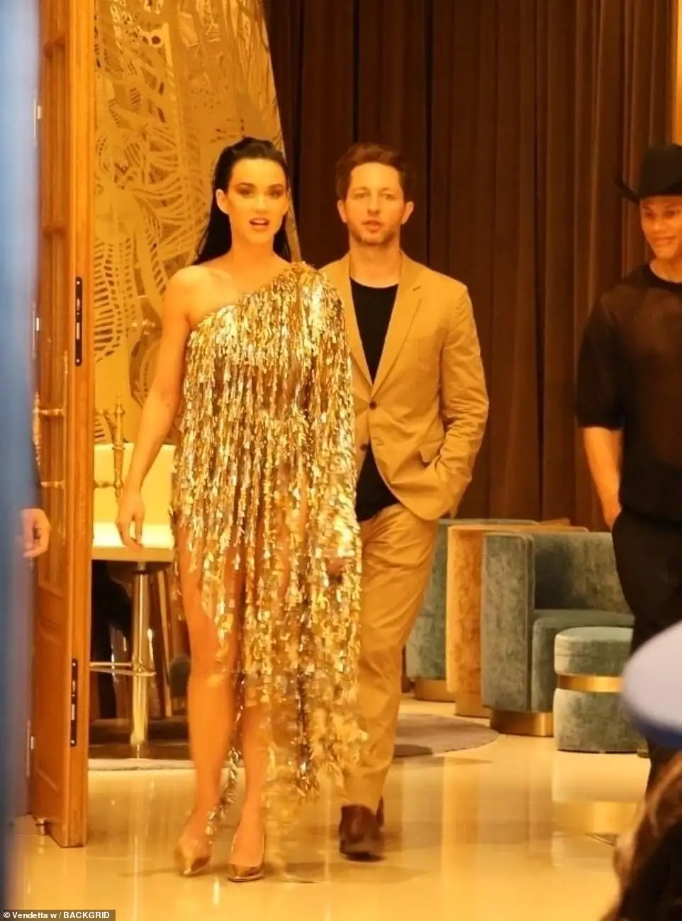 Katy arrived at Maxim's in the dazzling gold number, teamed with matching court heels