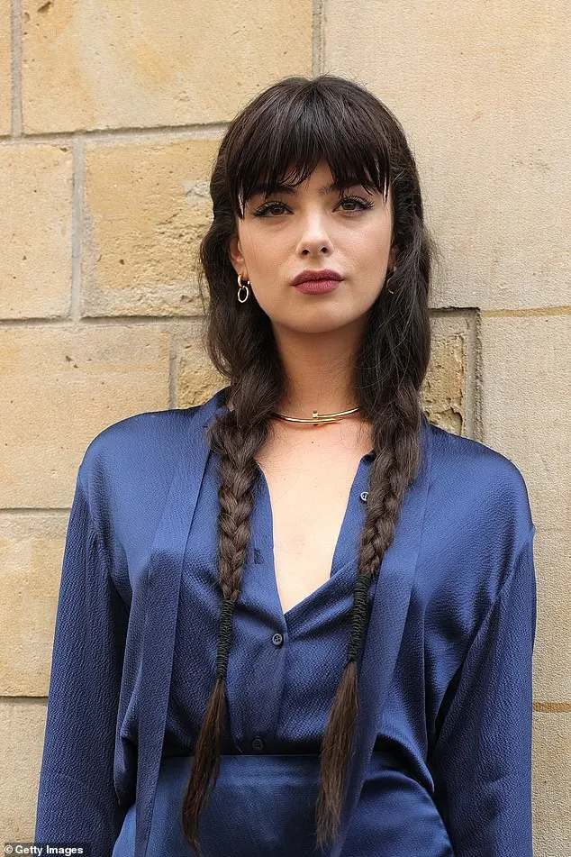 She wore her long brown locks in plaits and accessorized with gold earrings, a chunky choker, and a ring