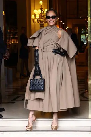 Jennifer Lopez leaves her hotel for the Dior couture fashion show wearing a khaki dior dress and coat with a black lady dior bag