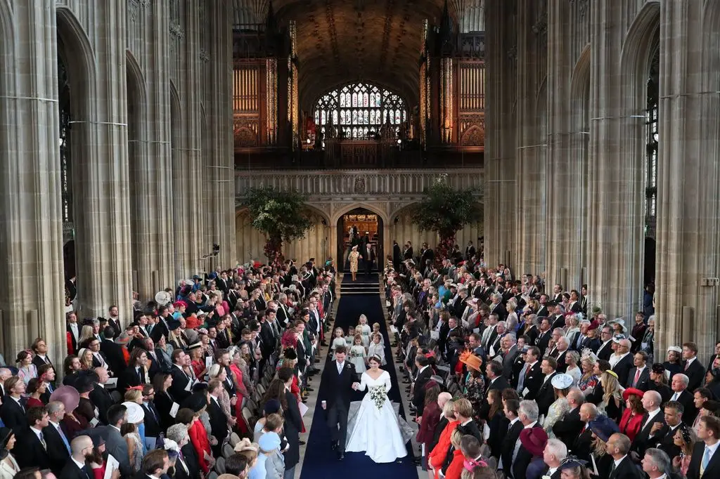 Princess Eugenie and Jack Brooksbank holding hands walking down the aisle