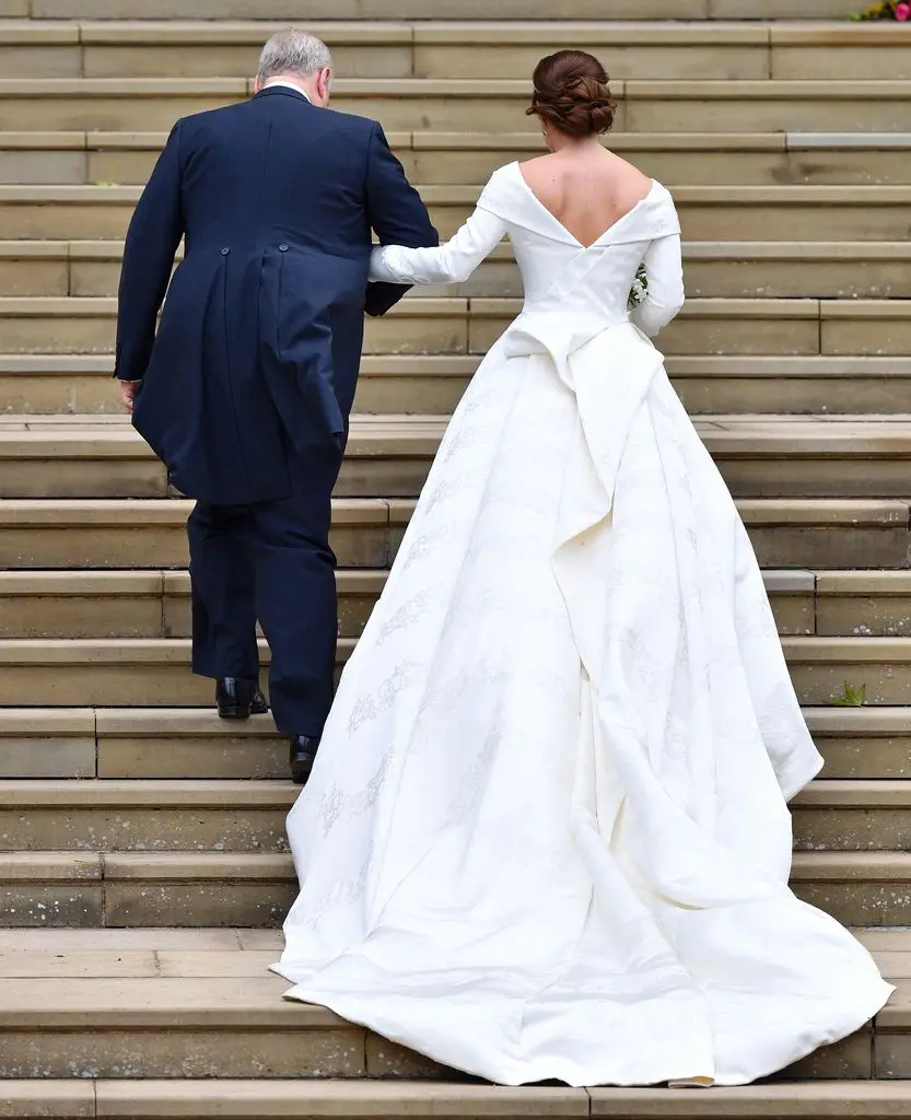 Prince Andrew and Princess Eugenie walk up the steps ahead of her royal wedding