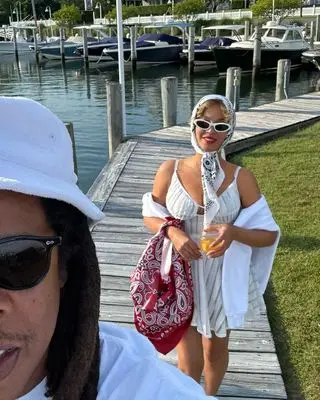 beyonce wearing a white bandana white sundress and white sunglasses