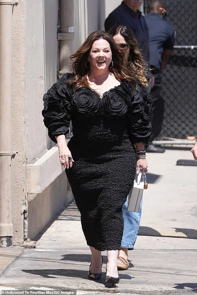 Melissa McCarthy flaunted her shrinking 5ft2in figure in a glamorous dress while heading inside El Capitan Entertainment Center in Hollywood on Thursday to pre-tape her 15th appearance on the ironically titled Jimmy Kimmel Live!