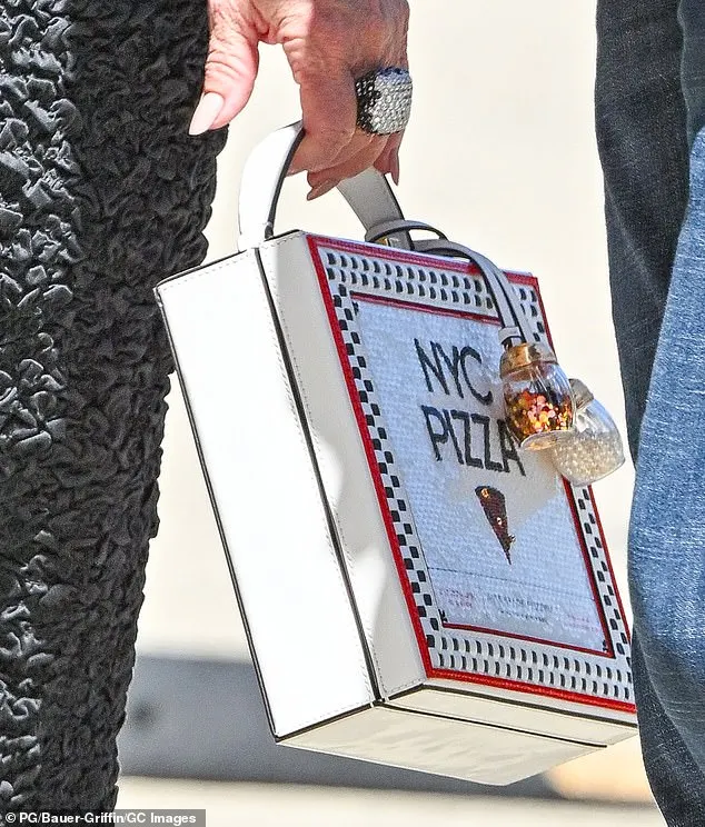 Melissa showed her quirky side by accessorizing with a $498 Kate Spade 'Slice 3D Pizza Box Top-handle Bag'