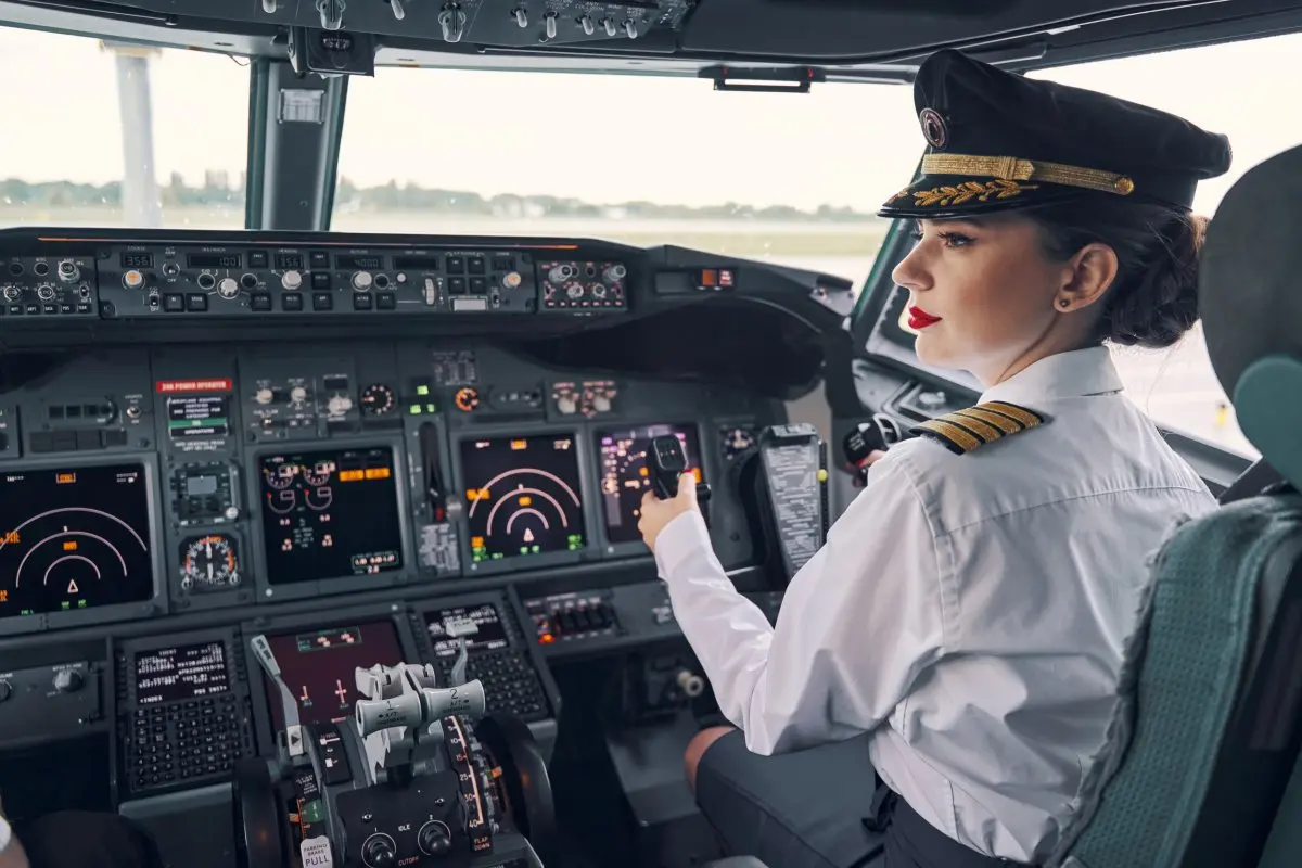 Female pilot sitting in plane cockpit.