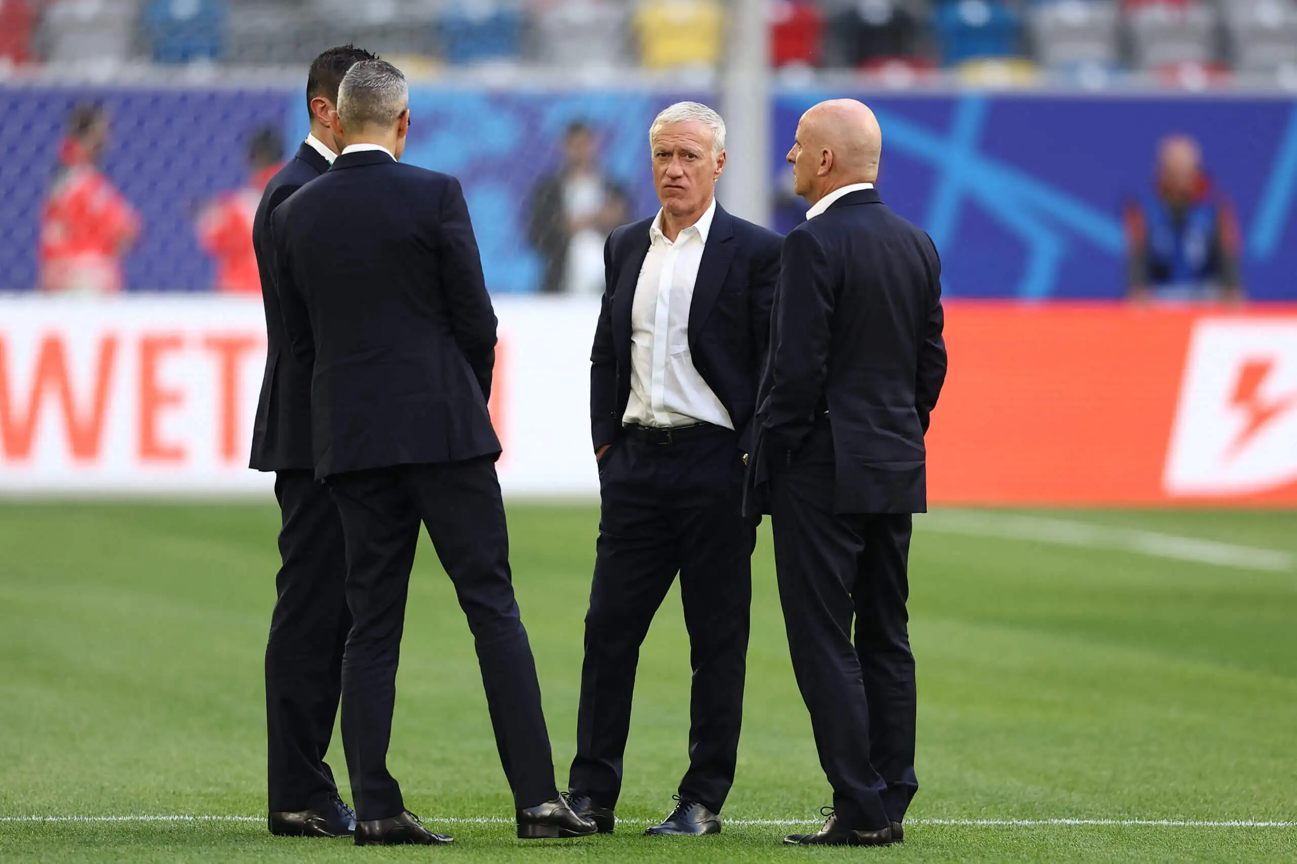 Didier Deschamps and his backroom staff on the pitch wearing suits