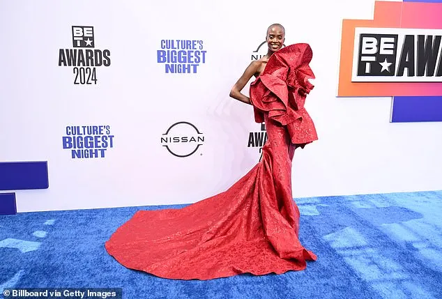 Madison Rian wowed as she arrived to the event in a figure-hugging, strapless red gown with dramatic, ruffled details n the front and a long train that flowed down behind the model