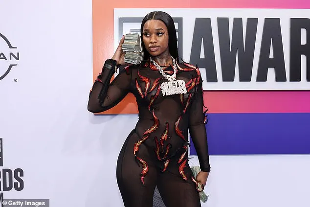 While posing on the red carpet, the rapper held a large stack of fake cash in her hands, and at one point, tossed a few bills into the air