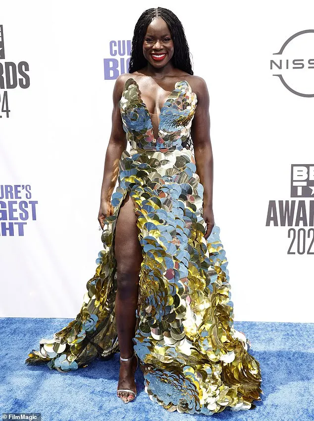 Tunde Oyeneyin was radiant in a gold and silver, sequin gown that had a plunging neckline on the front as well as a thigh-high slit on the right side