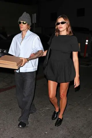 Justin and Hailey Bieber walking with a pizza box