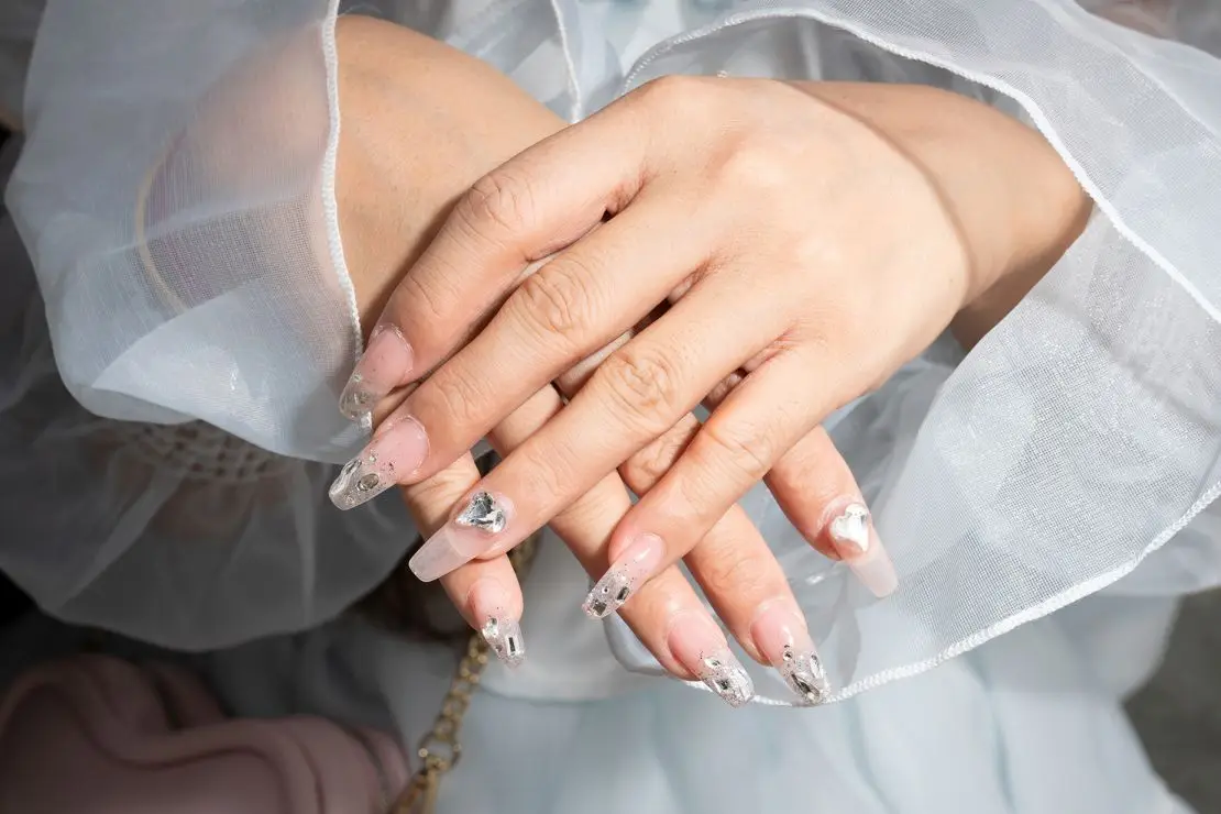 Li shows off an ornate manicure that complements her look.