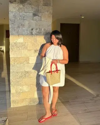 Influencer wears red shoes with a white dress.