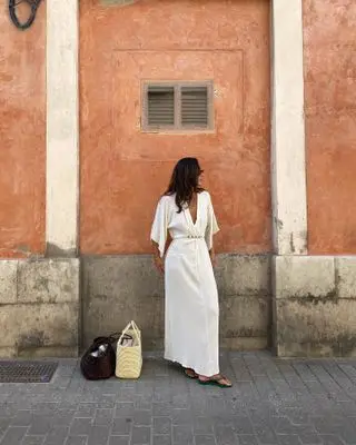 Influencer wears green shoes with a white dress.