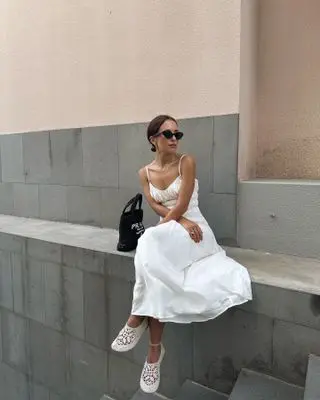 Influencer wears white shoes with a white dress.