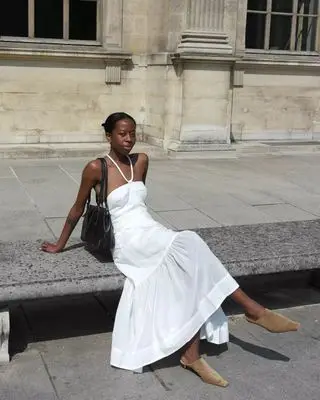 Influencer wears beige shoes with a white dress.