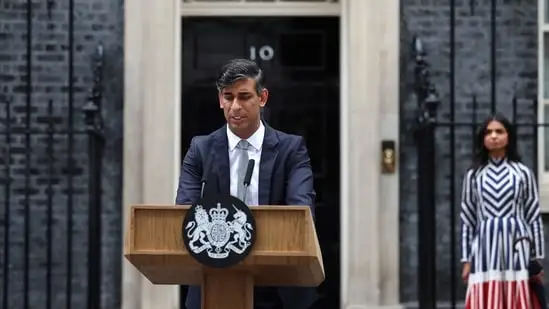 Britain's outgoing Prime Minister and leader of the Conservative party, Rishi Sunak, delivers a statement after his general election defeat outside 10 Downing Street in London as his wife, Akshata Murty, stands at a distance. (AFP)