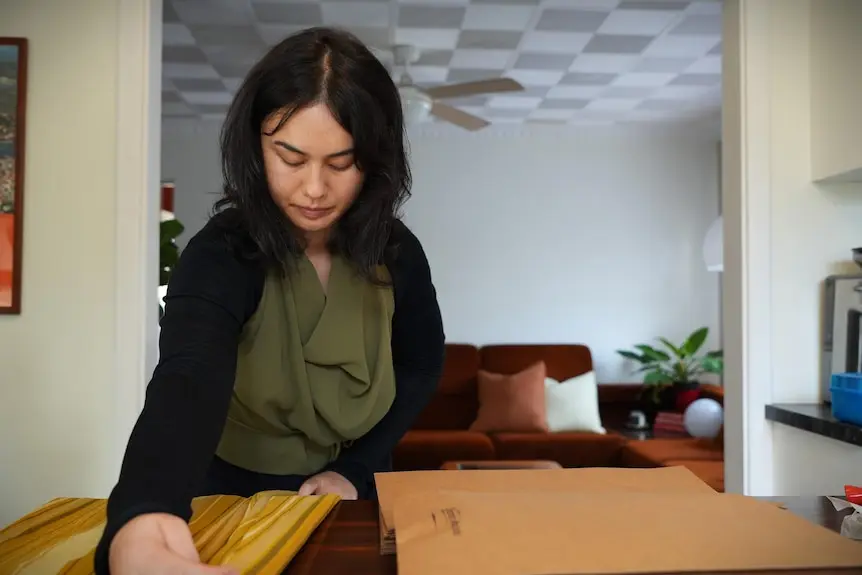 A woman named Shannon Malone fold an item of clothing.