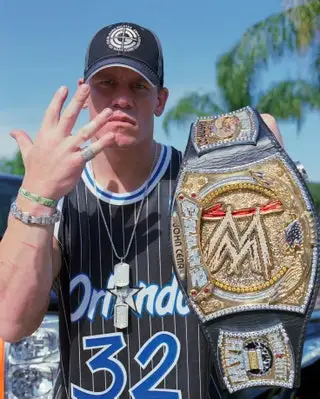 Image may contain John Cena Baseball Cap Cap Clothing Hat Accessories Jewelry Ring Vest TShirt and Bracelet