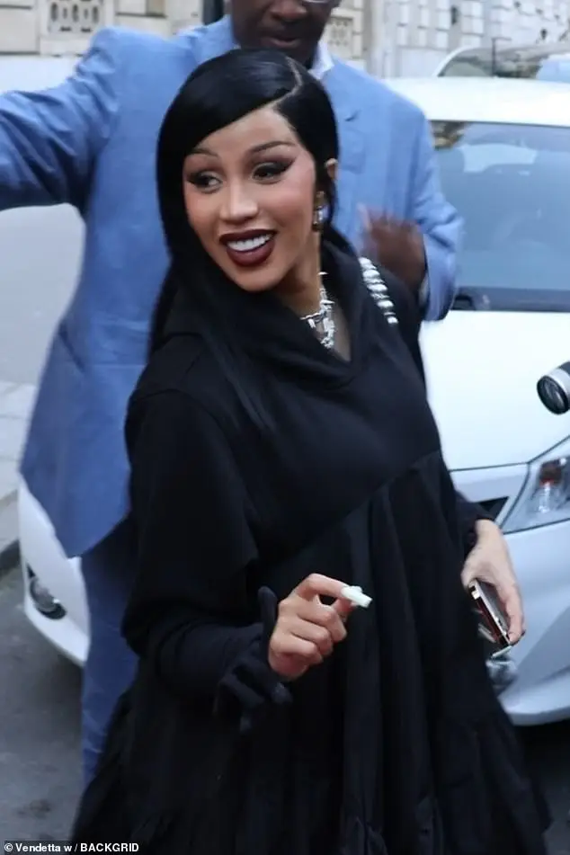 The rapper, 31, opted for a smoky eye and heavy winged eyeliner as well as a deep red lipstick, while her long white nails contrasted the look