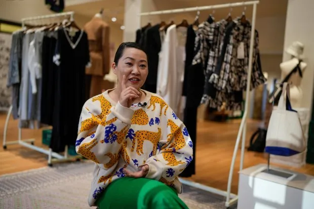 Zhang Na, whose fashion label, Reclothing Bank, sells clothes, bags and other accessories made from materials such as plastic bottles, fishing nets and flour sacks, speaks during an interview at her store in Shanghai on March 19, 2024. ( AP Photo/Ng Han Guan )