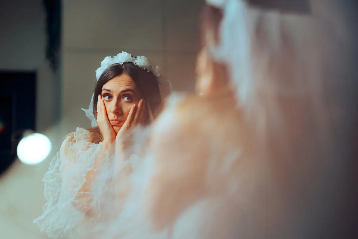 A woman appears overwhelmed in wedding dress