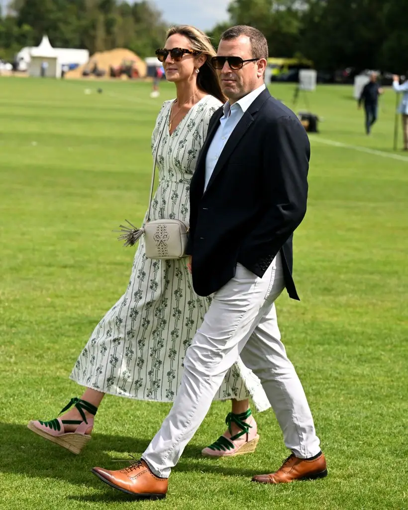 Harriet Sperling and Peter Phillips walk across polo field