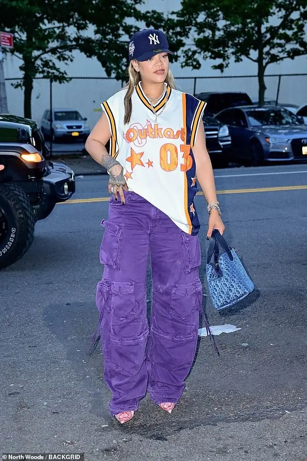 The 36-year-old Bajan billionaire wore a NY Yankees cap over her blonde wig, a jersey for the six-time Grammy-winning rap duo Outkast, purple denim cargo pants, and pink reptillian heels