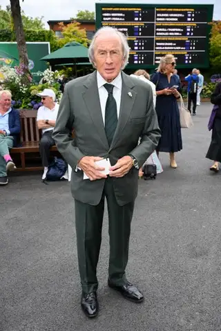 Image may contain Jackie Stewart Person Clothing Formal Wear Suit Accessories Bag Handbag Footwear Shoe and Tie