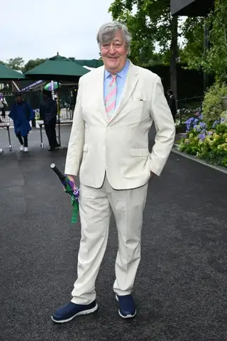 Image may contain Stephen Fry Person Clothing Formal Wear Suit Blazer Coat Jacket Accessories Tie Face and Head