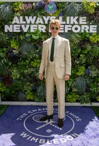 Image may contain Thomas BrodieSangster Blazer Clothing Coat Jacket Person Standing Formal Wear and Suit