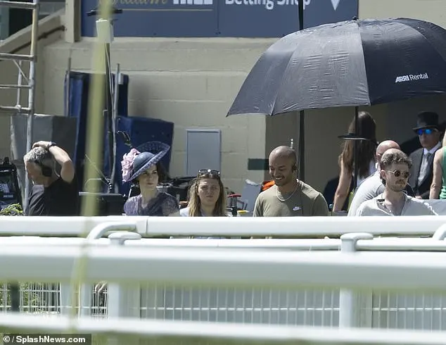 The extras were spotted shielding from the sun under umbrellas and sipping from cups of water as cameras rolled for hours on some of the hottest days of the year so far