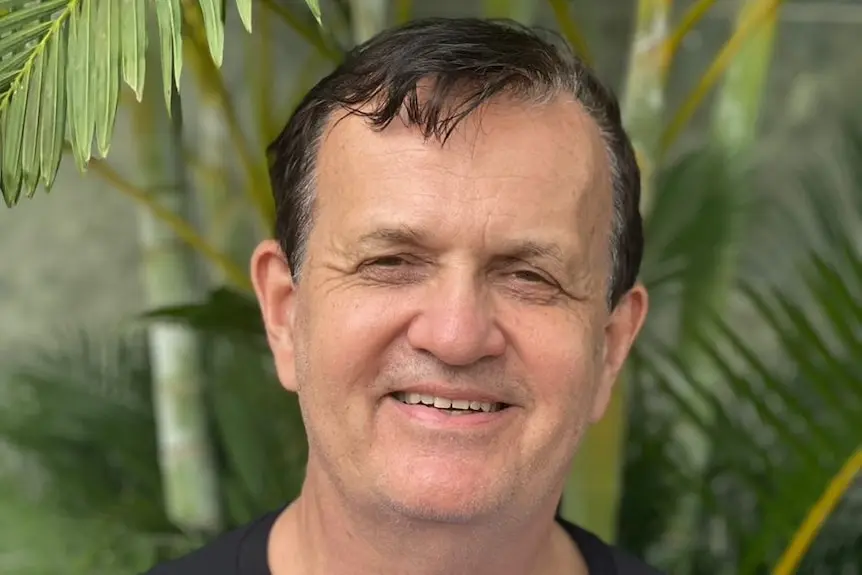 A man with dark hair smiling at the camera.