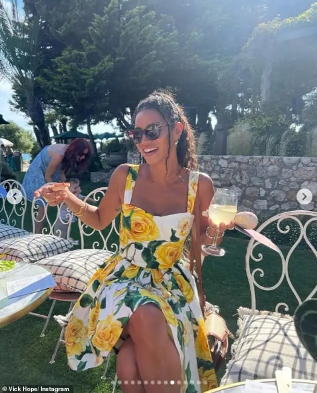 One stunning snap saw her showing off her long legs in a white and yellow rose dress, as she enjoyed a drink in the sunshine