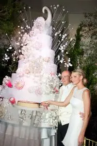 MONACO - JULY 2: In this handout image provided by the Palais Princier, Princess Charlene of Monaco and Prince Albert II of Monaco cut the cake during the religious ceremony of the Royal Wedding, in the main courtyard at Prince's Palace on July 2, 2011 in Monaco. The Roman-Catholic ceremony followed the civil wedding which was held in the Throne Room of the Prince's Palace of Monaco on July 1. With her marriage to the head of state of the Principality of Monaco, Charlene Wittstock has become Princess consort of Monaco and gains the title, Princess Charlene of Monaco. Celebrations including concerts and firework displays are being held across several days, attended by a guest list of global celebrities and heads of state. (Photo by Eric Mathon - Palais Princier via Getty Images)